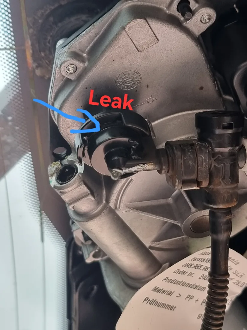 Rear wiper motor washer-fluid elbow inside the Audi Q8 tailgate, with the leak location identified