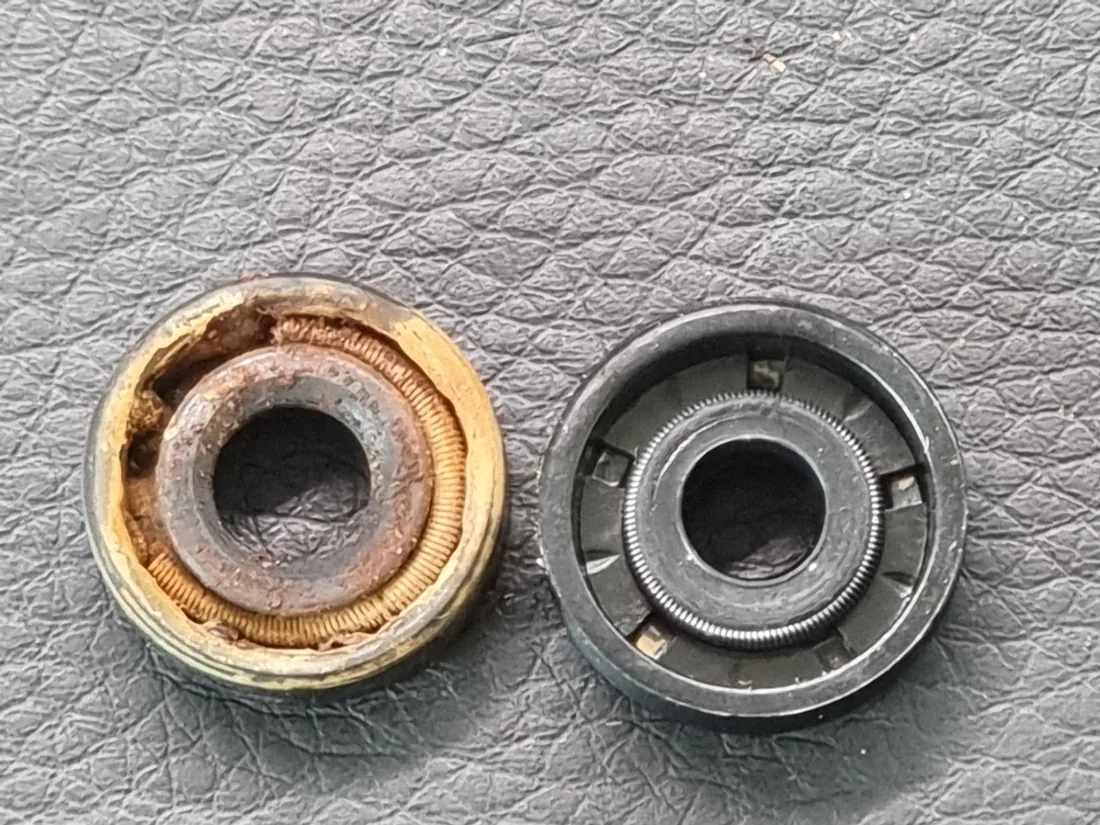 Corroded original Audi rear wiper washer seal next to a clean compatible replacement